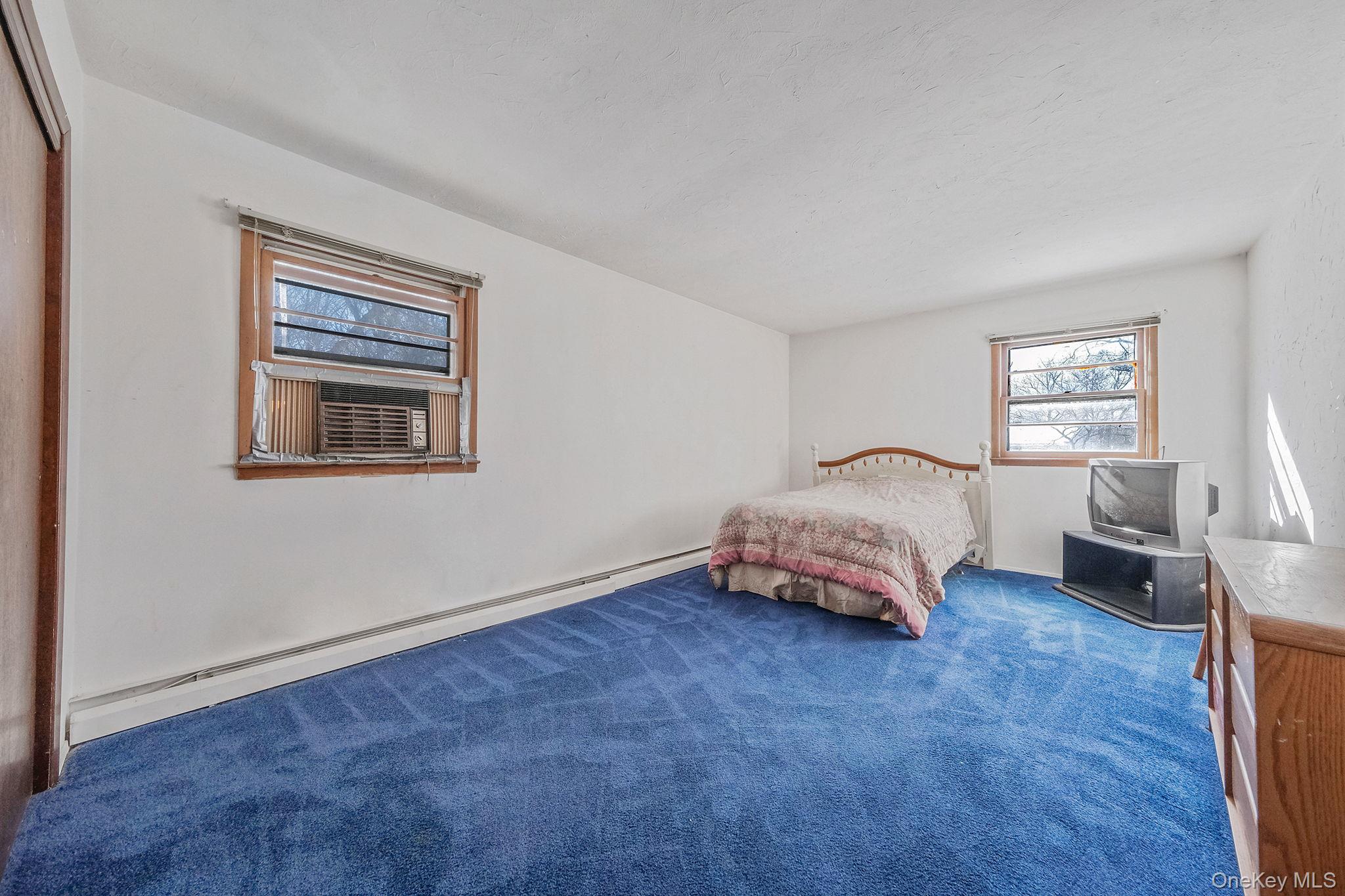 140 Seaman Neck Road Dix Hills, NY 11746 - Photo 12 of 21 a bedroom with a bed and a couch