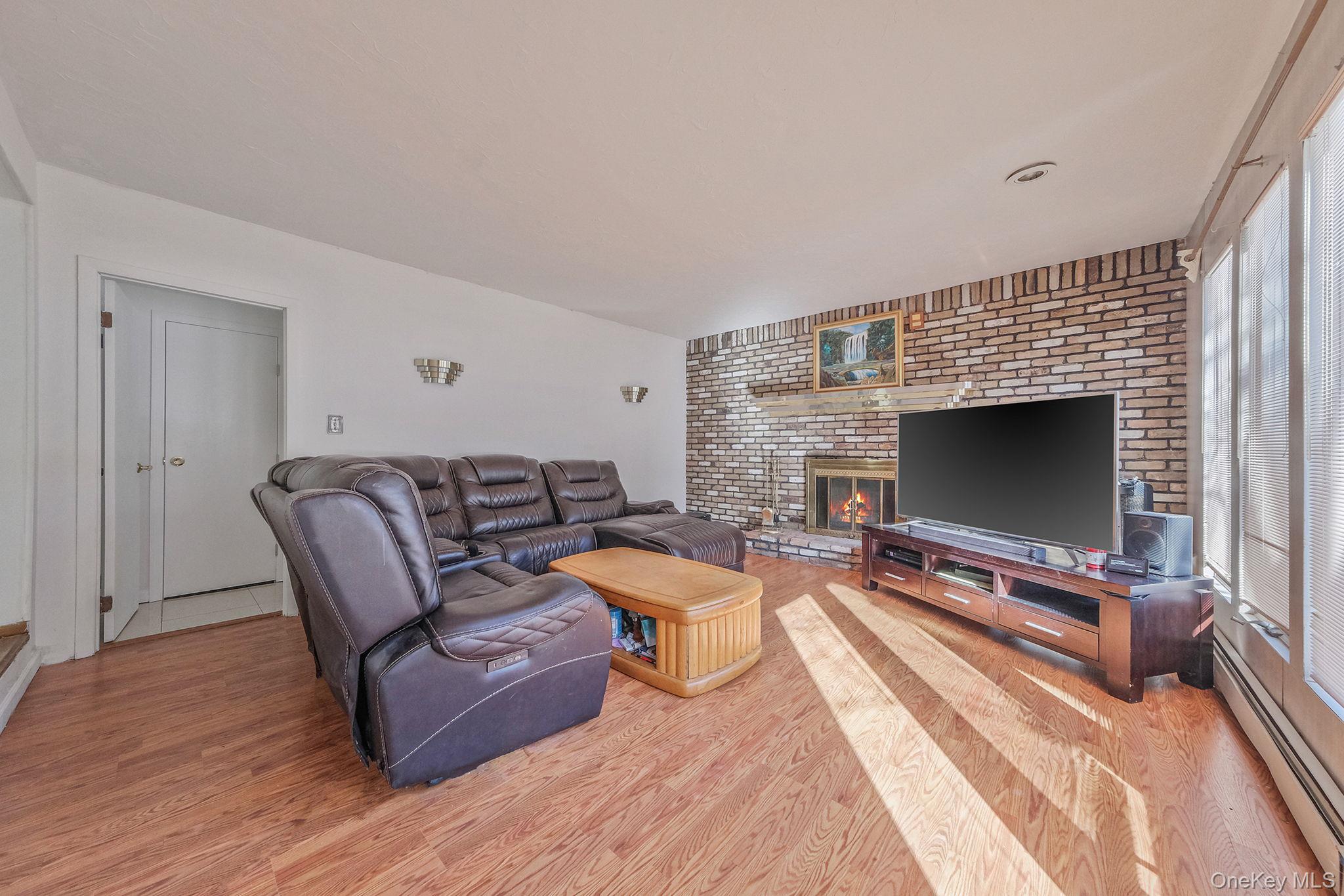140 Seaman Neck Road Dix Hills, NY 11746 - Photo 7 of 21 a living room with furniture a flat screen tv and a fireplace