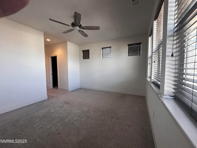 a view of a livingroom with a ceiling fan and window