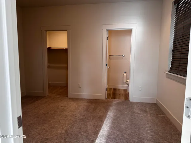an empty room with closet and windows