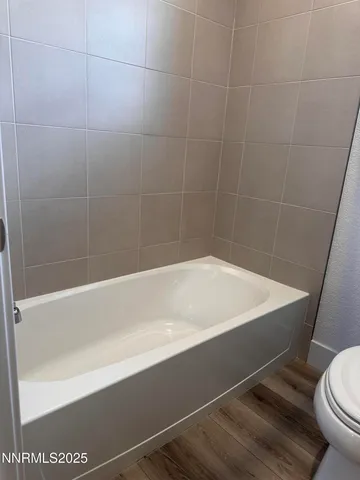 a bath tub sitting next to a white toilet