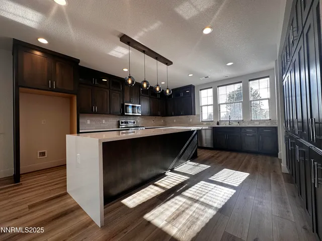 a kitchen with stainless steel appliances kitchen island granite countertop a stove a sink and a refrigerator