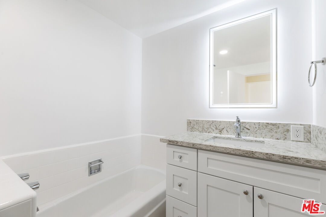 4455 Los Feliz Boulevard, Unit 1005 Los Angeles, CA 90027 - Photo 16 of 17 a bathroom with a granite countertop sink and a bathtub