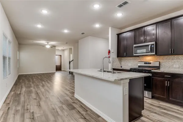 a kitchen with stainless steel appliances granite countertop a sink stove and oven