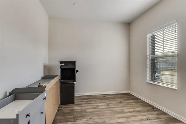 a view of a kitchen with an empty space and wooden floor