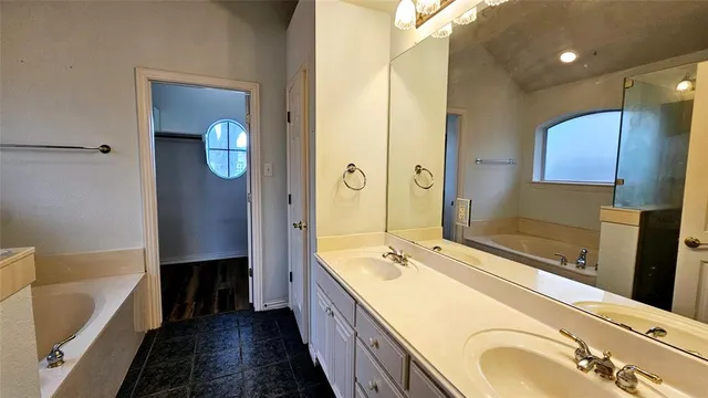a bathroom with a tub sink and mirror