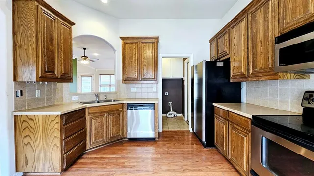 a kitchen with stainless steel appliances granite countertop a stove a sink dishwasher and a refrigerator