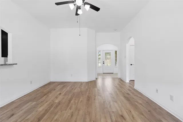 a view of an empty room with wooden floor