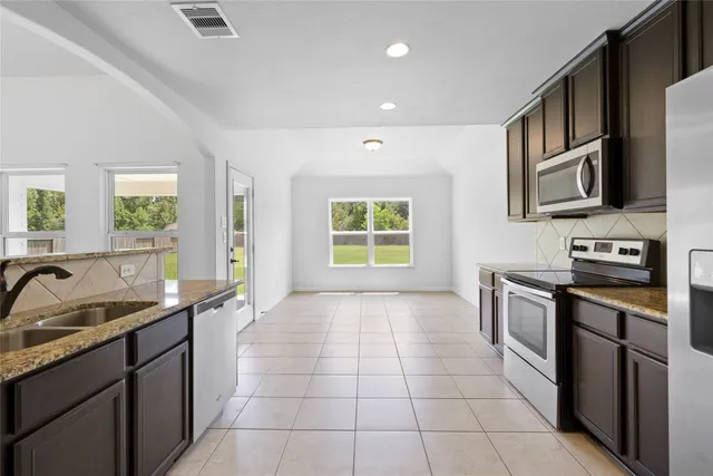 a kitchen with a sink stove and cabinets