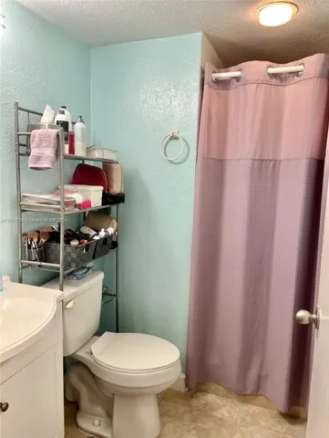 a bathroom with a sink toilet vanity and shower