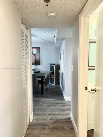 a view of a hallway with furniture and a window