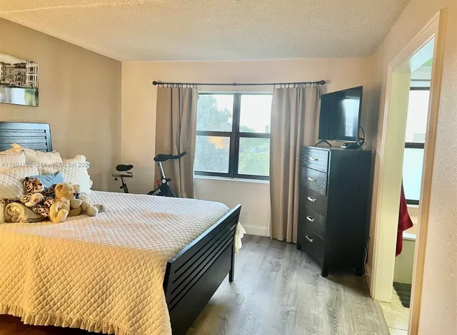 a bedroom with a bed and a dresser next to a window