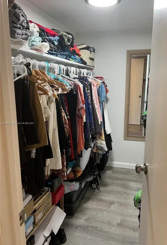 a view of walk in closet with clothes and shoes