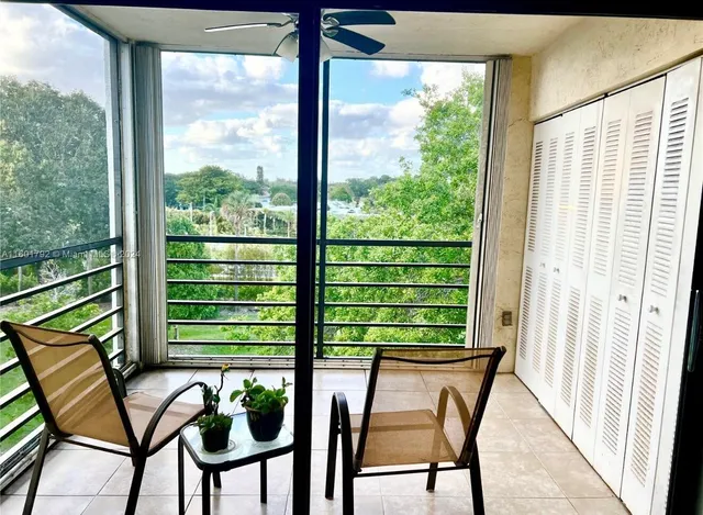 a balcony view with chairs and a potted plant