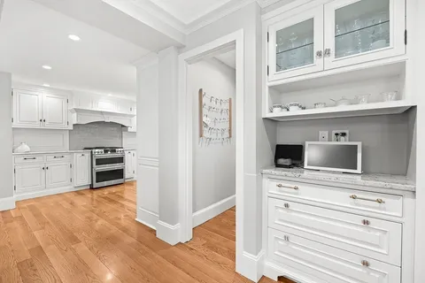a kitchen with granite countertop a stove a sink and a refrigerator with wooden floor