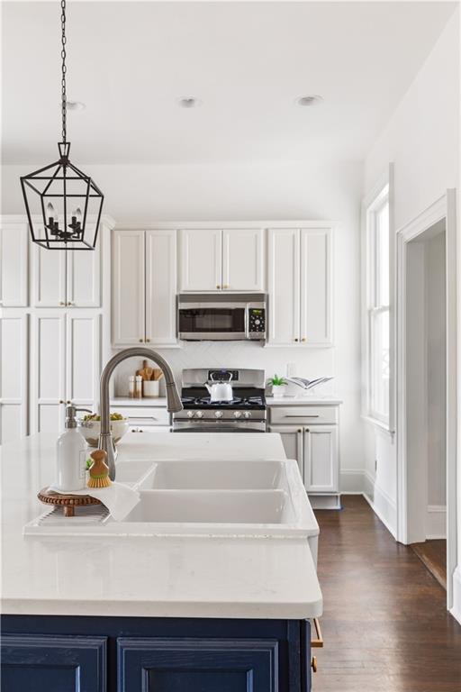 679 Lawton Street Southwest Atlanta, GA 30310 - Photo 19 of 45 a kitchen with stainless steel appliances a sink a stove a refrigerator cabinets and a window