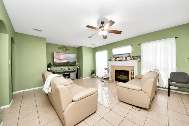a living room with furniture a flat screen tv and a fireplace