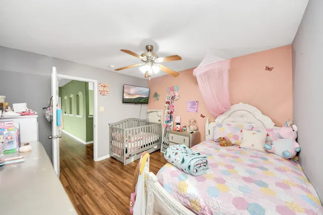 a bedroom with a bed mirror and on the dresser