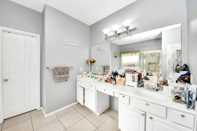 a kitchen with a sink dishwasher a stove and white cabinets