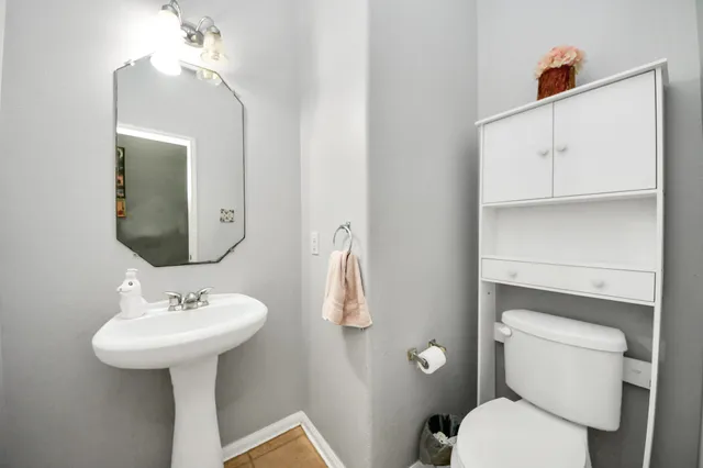 a bathroom with a toilet sink and mirror