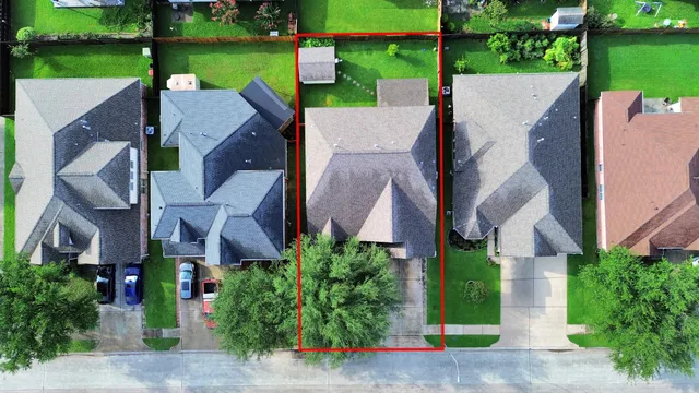 an aerial view of a house with a yard and lake view