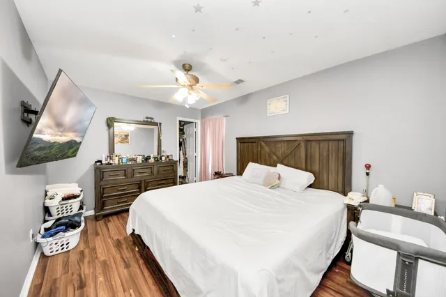 a bedroom with a bed and a flat tv screen on dresser
