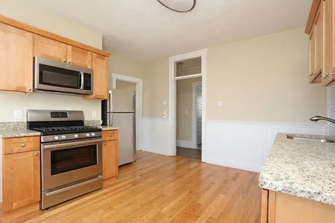 a kitchen with stainless steel appliances granite countertop a stove a microwave and a refrigerator