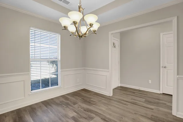 a view of a room with wooden floor and chandelier