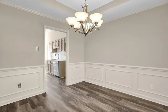 a view of a kitchen with wooden floor and a chandelier