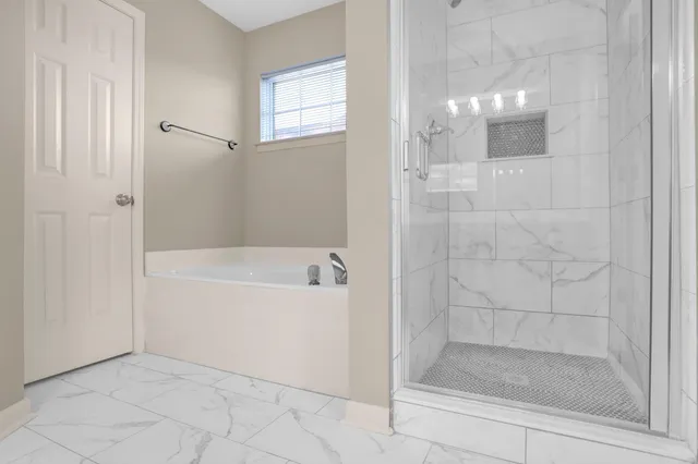 a bathroom with a bathtub and shower