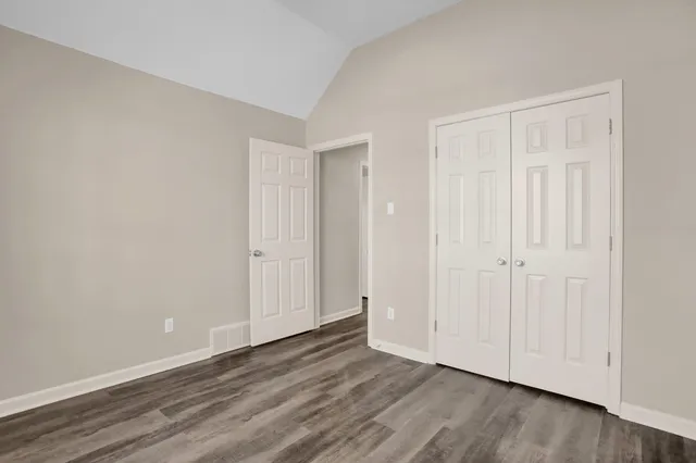 a view of an empty room with wooden floor