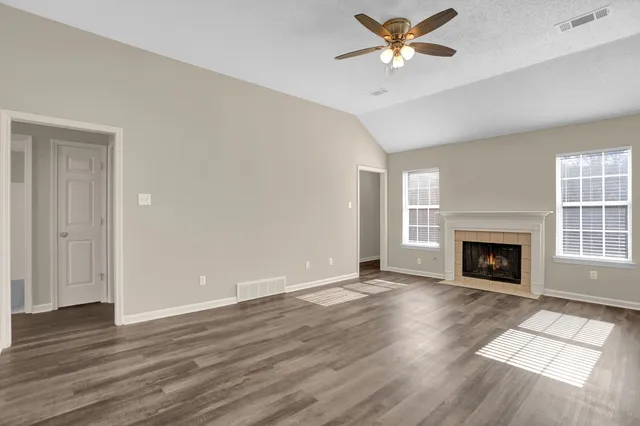 wooden floor fireplace and windows in an empty room