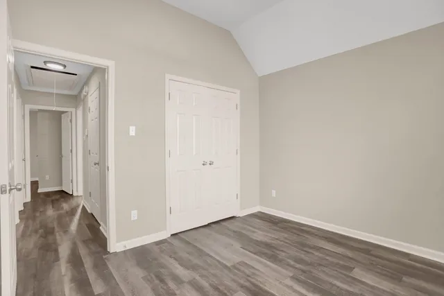 a view of a livingroom with wooden floor and a bathroom