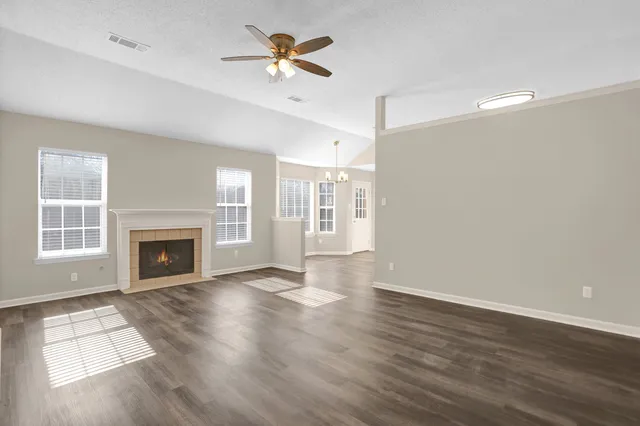 a view of an empty room with a fireplace and a window