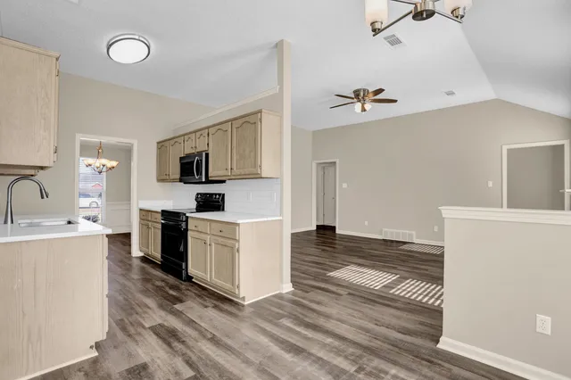a kitchen with granite countertop a stove a sink and a refrigerator