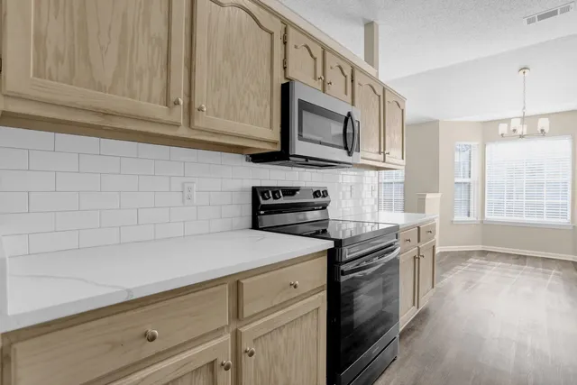 a kitchen with stainless steel appliances a stove microwave and cabinets