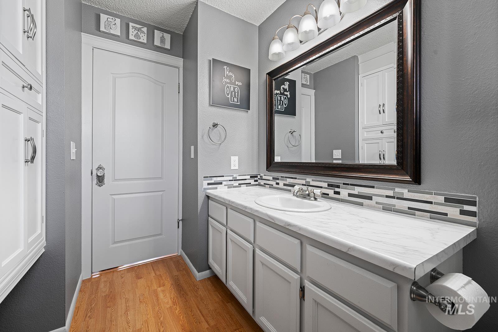 2007 Ripon Avenue Lewiston, ID 83501 - Photo 11 of 30 Bathroom vanity featuring a single basin sink, laminate countertop, and a mosaic tile backsplash