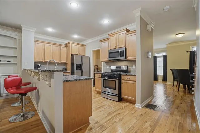 a kitchen with stainless steel appliances granite countertop a refrigerator stove microwave and sink