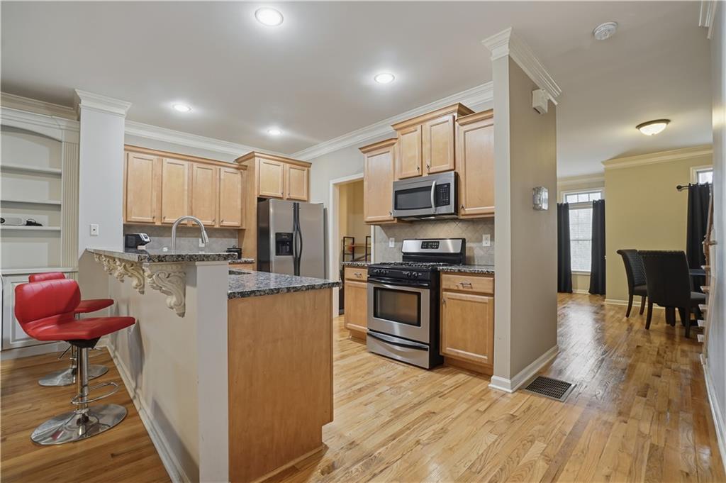 4414 George David Way Powder Springs, GA 30127 - Photo 4 of 29 a kitchen with stainless steel appliances granite countertop a refrigerator stove microwave and sink