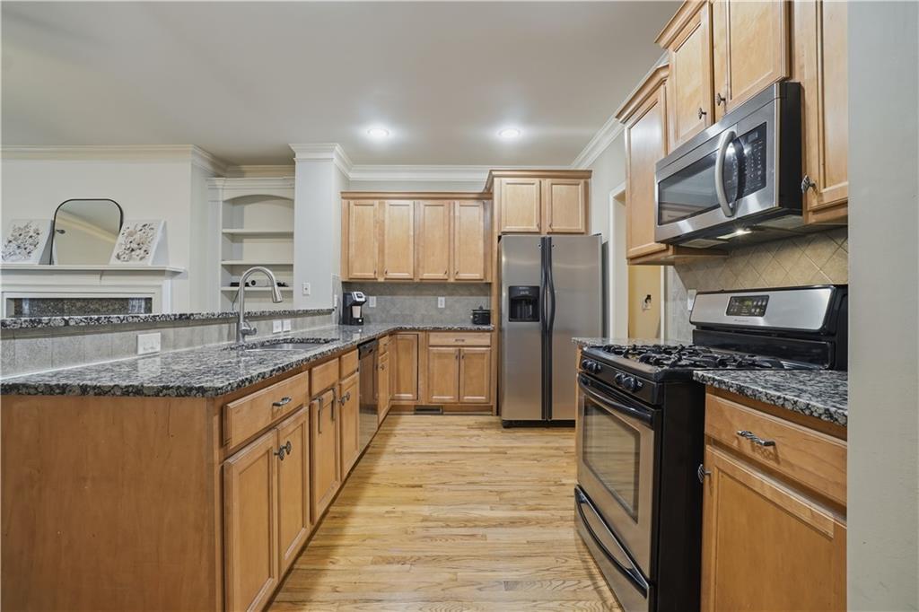4414 George David Way Powder Springs, GA 30127 - Photo 5 of 29 a kitchen with stainless steel appliances granite countertop a stove a sink dishwasher a refrigerator and cabinets with wooden floor