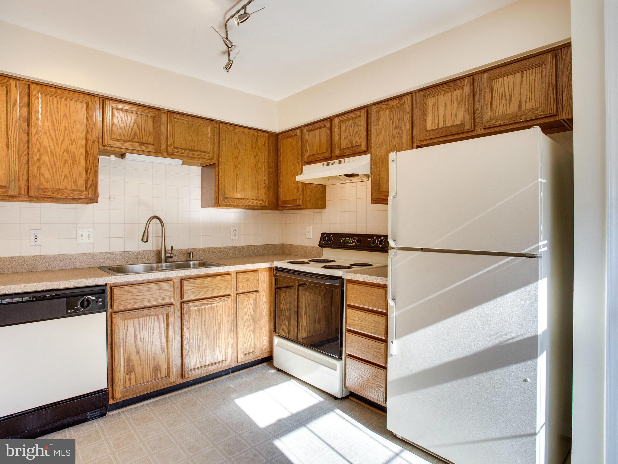 6395 Stagg Court Springfield, VA 22150 - Photo 10 of 30 a kitchen with granite countertop a sink and a refrigerator
