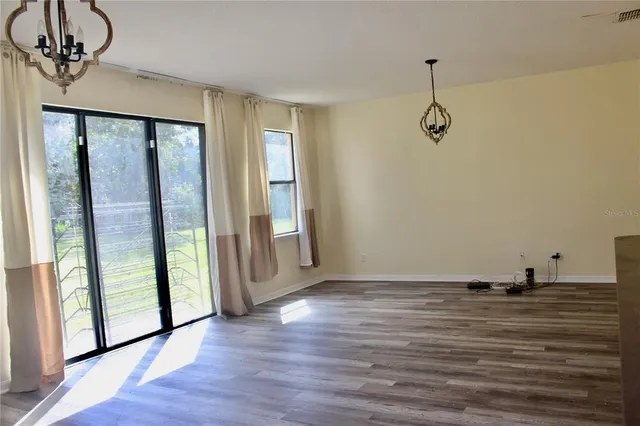 a view of a room with wooden floor and windows