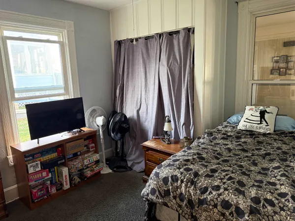 a bedroom with a bed and a flat tv screen