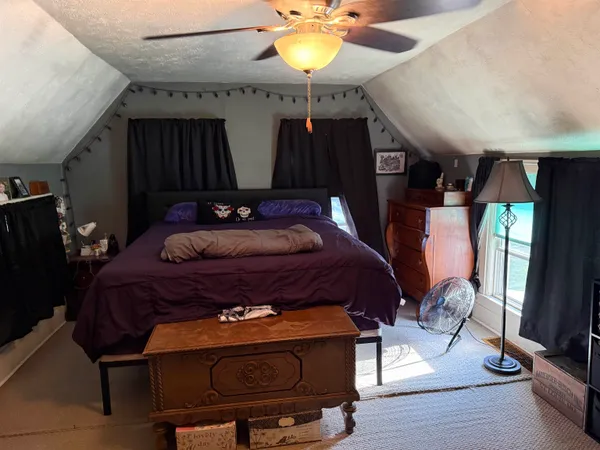 a bedroom with bed window and wooden floor