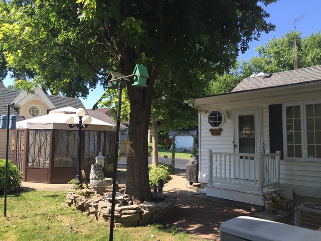 1619 Riverside Drive McHenry, IL 60050 - Photo 23 of 25 a view of a patio with table and chairs with wooden fence and plants
