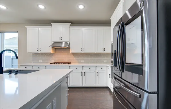 a view of an empty room with wooden floor and a fireplace