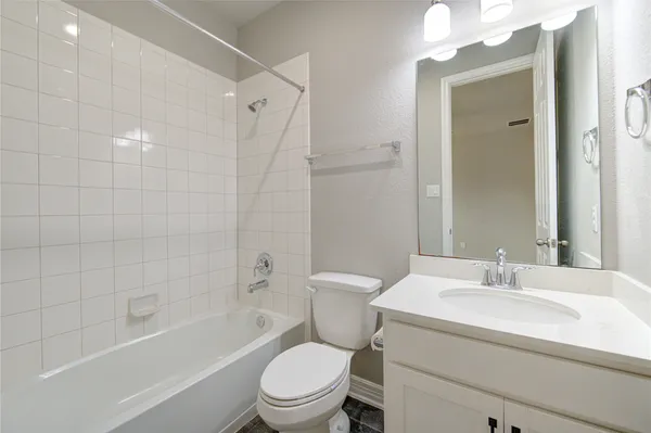 a kitchen with stainless steel appliances granite countertop a stove a sink and white cabinets with wooden floor next to windows