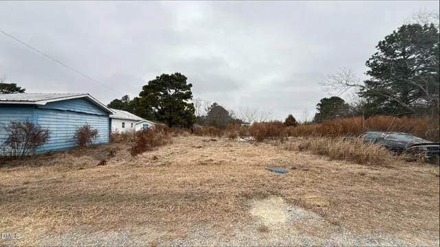 a view of wooden house with a yard