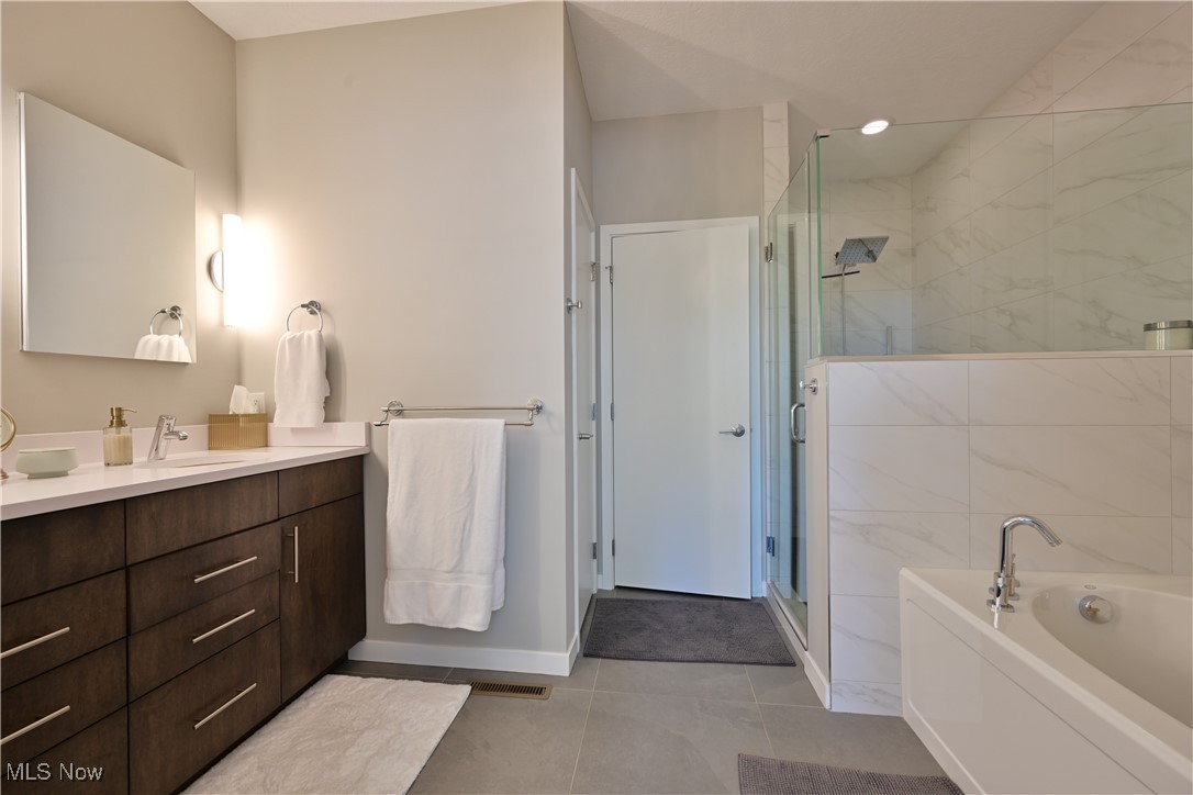 18875 Riversouth Fairview Park, Unit 30 Cleveland, OH 44126 - Photo 20 of 39 Full bathroom featuring vanity, a garden tub, a shower stall, and light tile patterned floors