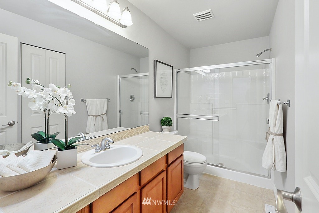 27714 Maple Ridge Way Southeast Maple Valley, WA 98038 - Photo 21 of 38 a bathroom with a granite countertop sink a toilet and shower